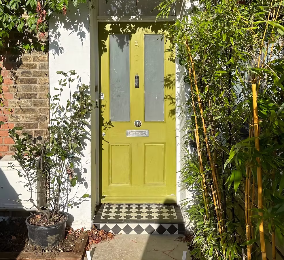 Period front door framed by bamboo and planting at a Thames Ditton Victorian garden