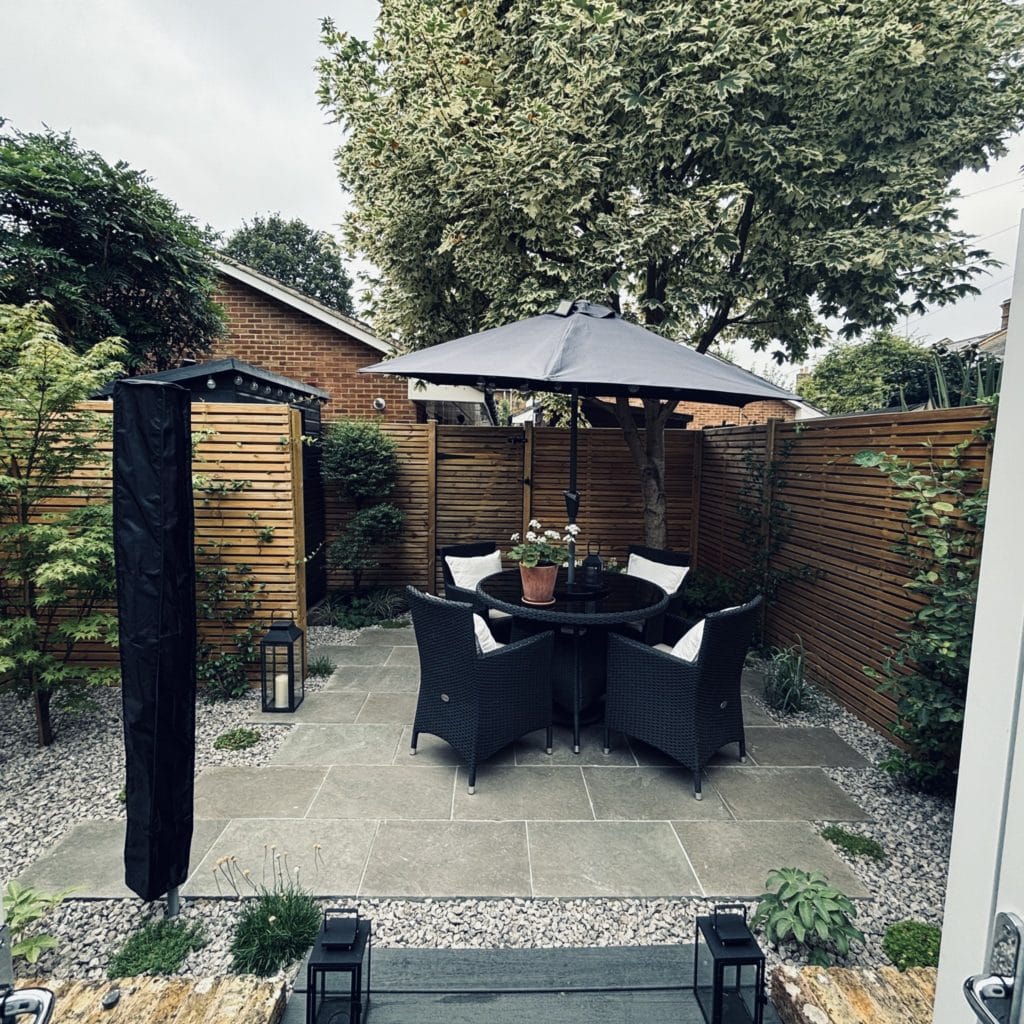 Finished Surbiton courtyard garden with pale paving, gravel planting beds and slatted fencing, by Flourish Landscaping