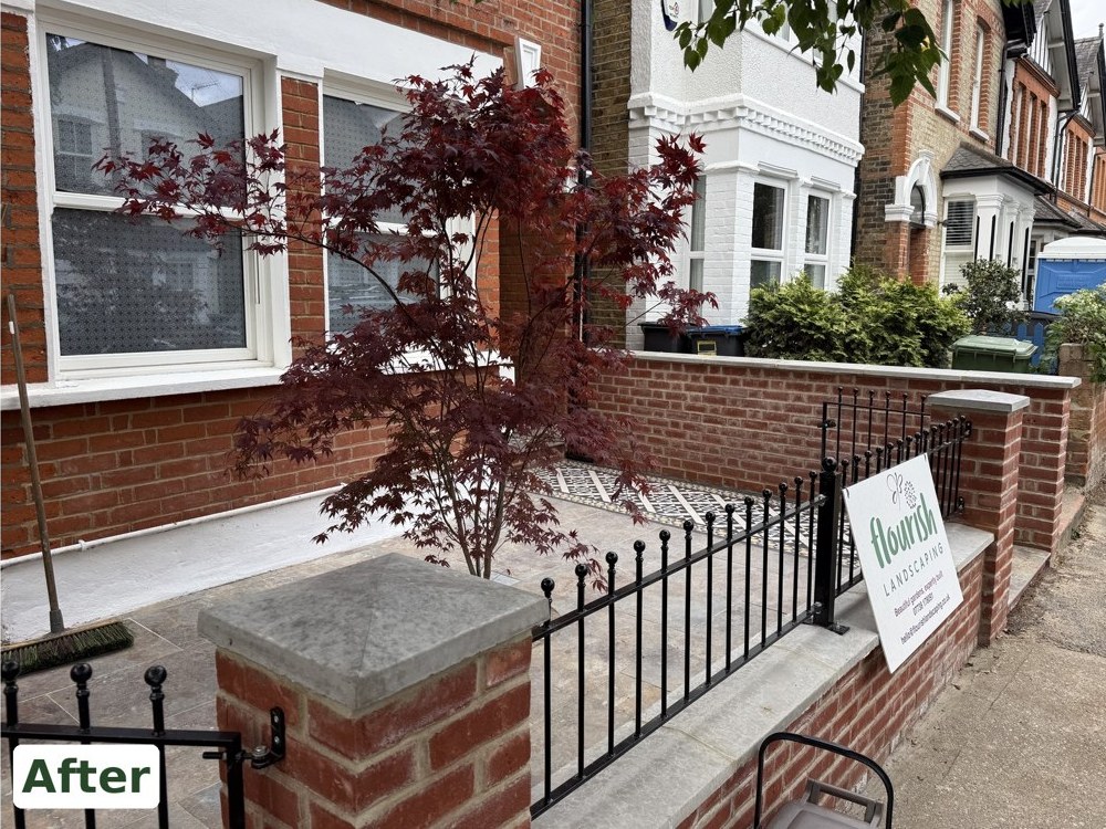 After: a new brick front wall with stone copings and black railings, tumbled limestone and a red-leaved Acer palmatum in front of the bay, by Flourish Landscaping in Kingston
